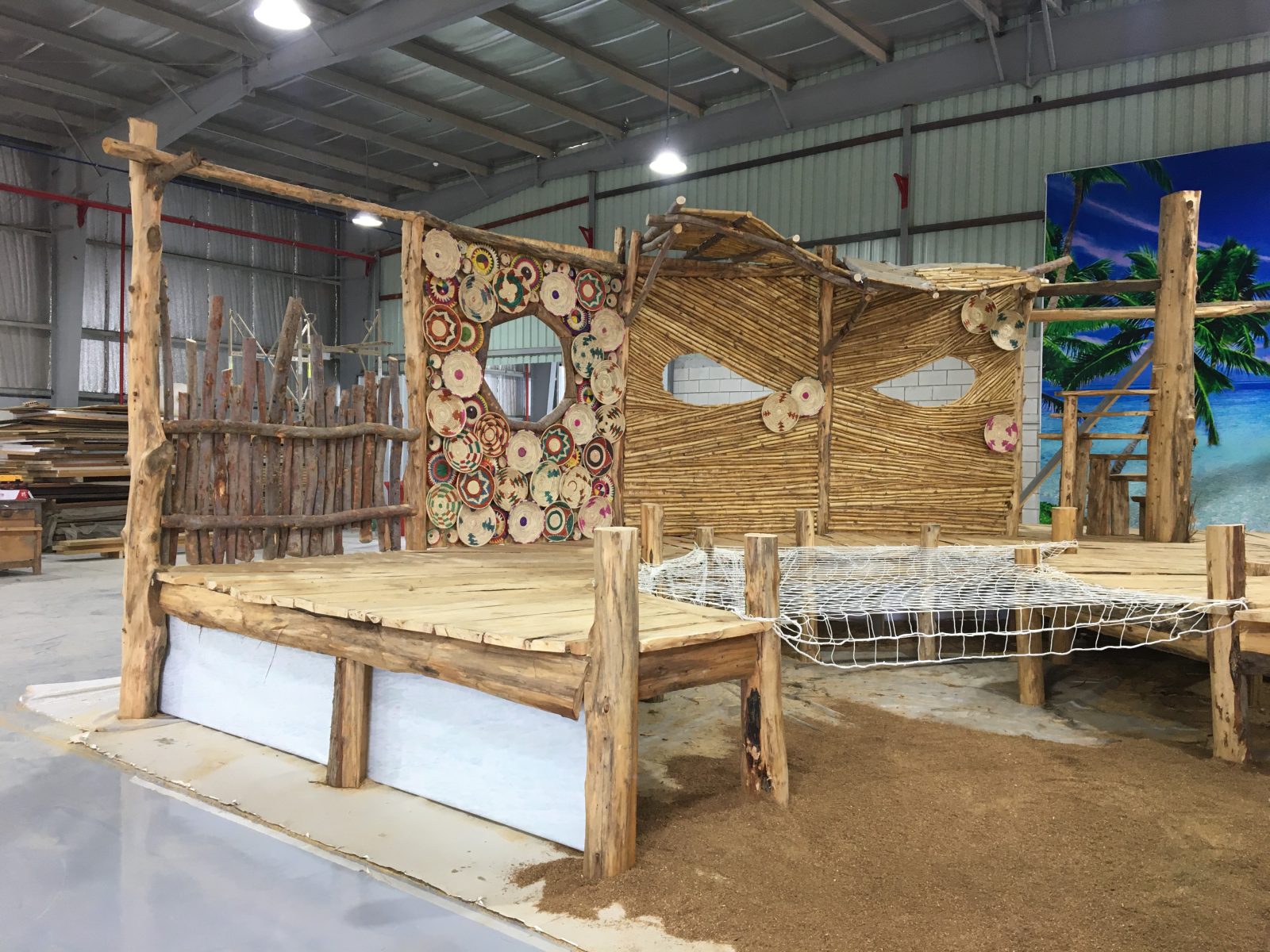 Hand-carved wooden bed on the STARK factory floor